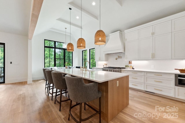 408 Ideal Way, Charlotte, NC 28203 - kitchen featuring premium range hood, beamed ceiling, light wood-style floors, light countertops, and white cabinets