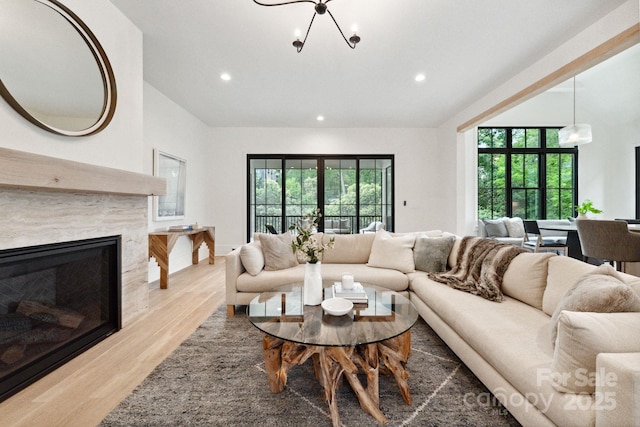 408 Ideal Way, Charlotte, NC 28203 - living room featuring wood finished floors, a chandelier, recessed lighting, lofted ceiling, and a premium fireplace
