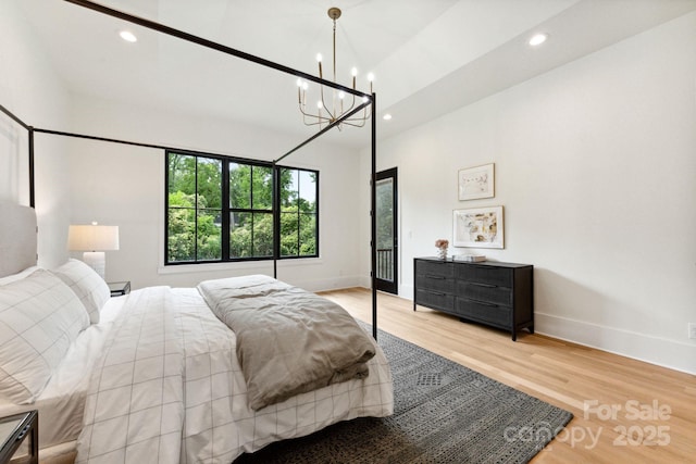 408 Ideal Way, Charlotte, NC 28203 - bedroom with recessed lighting, wood finished floors, a chandelier, access to exterior, and a towering ceiling