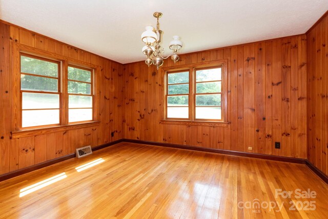 18 Gravely Branch Rd, Fletcher, NC 28732 - empty room with a chandelier, light wood finished floors, healthy amount of natural light, and wood walls