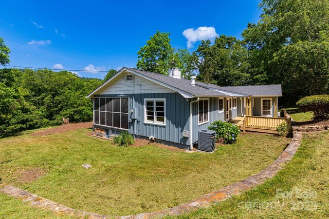 18 Gravely Branch Rd, Fletcher, NC 28732 - view of front facade featuring board and batten siding, a chimney, a front yard, a wooden deck, and roof with shingles