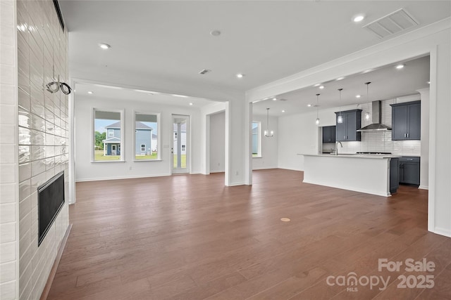 12009 Grinstead Ln Unit 303, Charlotte, NC 28278 - unfurnished living room with a tiled fireplace, a sink, wood finished floors, recessed lighting, and baseboards