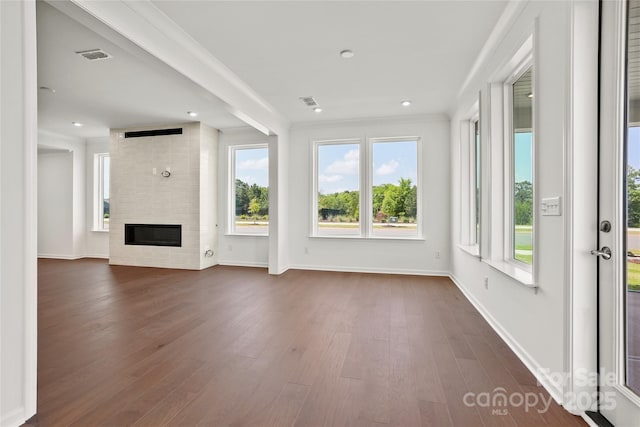 12009 Grinstead Ln Unit 303, Charlotte, NC 28278 - unfurnished living room featuring plenty of natural light, dark wood finished floors, baseboards, a fireplace, and recessed lighting