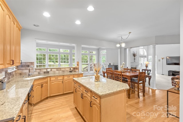 3213 Strawberry Rd, Matthews, NC 28104 - kitchen featuring a sink, light brown cabinets, a fireplace, a center island, and light stone countertops