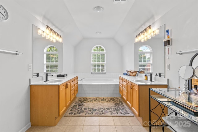 3213 Strawberry Rd, Matthews, NC 28104 - bathroom featuring healthy amount of natural light, two vanities, vaulted ceiling, a bath, and tile patterned floors