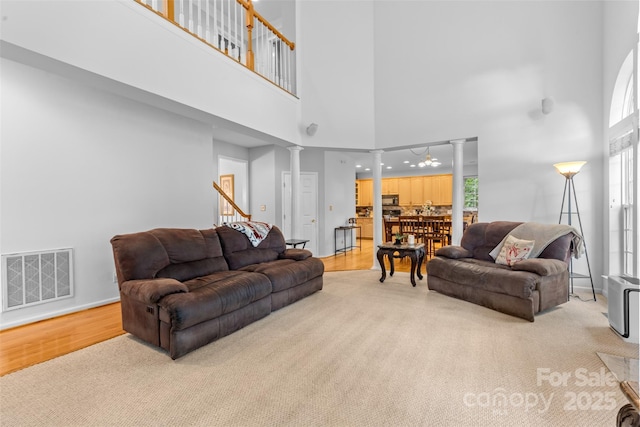 3213 Strawberry Rd, Matthews, NC 28104 - living area featuring decorative columns, a high ceiling, healthy amount of natural light, light wood-style floors, and stairway