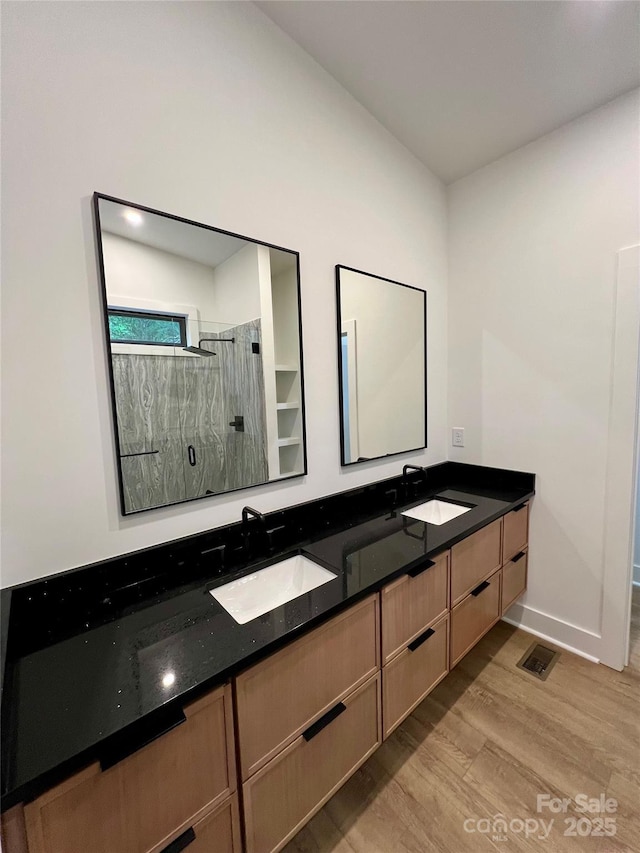 908 Apex Dr, Albemarle, NC 28001 - full bath with wood finished floors, double vanity, a stall shower, and baseboards