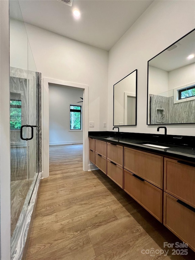 908 Apex Dr, Albemarle, NC 28001 - bathroom featuring double vanity, a shower stall, and wood finished floors