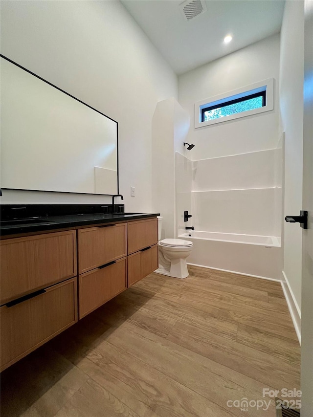 908 Apex Dr, Albemarle, NC 28001 - full bath featuring double vanity, toilet, wood finished floors, washtub / shower combination, and recessed lighting