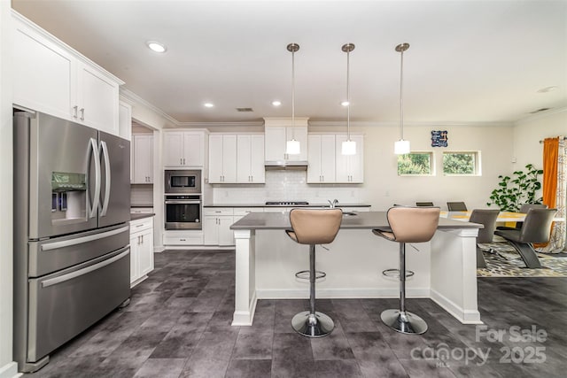 5098 Burnwald Ct, Fort Mill, SC 29715 - kitchen with stainless steel appliances, a breakfast bar, white cabinetry, dark countertops, and crown molding