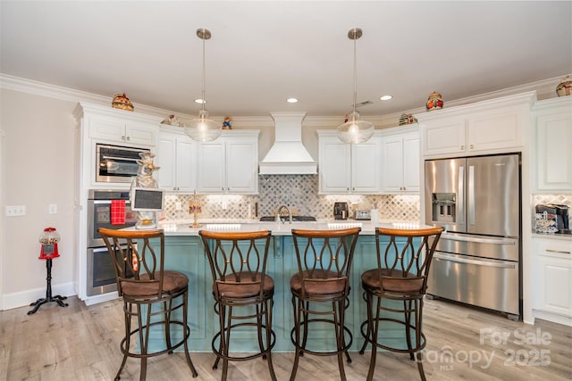3441 Club Ridge Ct, Gastonia, NC 28056 - kitchen with stainless steel appliances, custom exhaust hood, white cabinets, light wood-type flooring, and ornamental molding