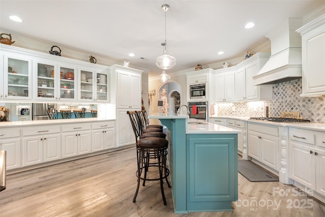 3441 Club Ridge Ct, Gastonia, NC 28056 - kitchen with stainless steel appliances, custom exhaust hood, light countertops, white cabinets, and a breakfast bar