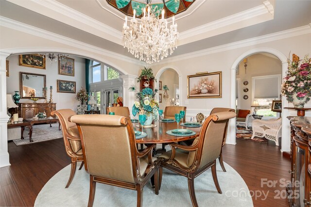 3441 Club Ridge Ct, Gastonia, NC 28056 - dining space featuring arched walkways, ornate columns, dark wood-style flooring, a tray ceiling, and crown molding