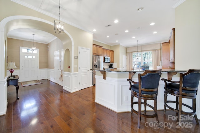 964 Knob Creek Ln, Fort Mill, SC 29708 - kitchen with stainless steel appliances, healthy amount of natural light, a breakfast bar, dark stone counters, and a wainscoted wall