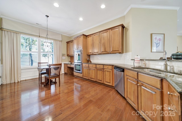 964 Knob Creek Ln, Fort Mill, SC 29708 - kitchen featuring stainless steel appliances, brown cabinets, stone countertops, wood finished floors, and crown molding