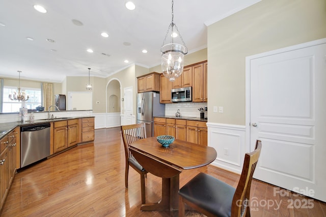 964 Knob Creek Ln, Fort Mill, SC 29708 - kitchen with stainless steel appliances, crown molding, a chandelier, arched walkways, and a decorative wall
