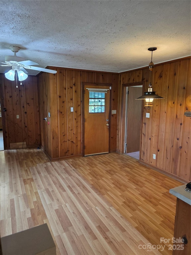 4298 NC-41 Hwy S, Fairmont, NC 28340 - entrance foyer featuring a textured ceiling, light wood-type flooring, a ceiling fan, and wood walls