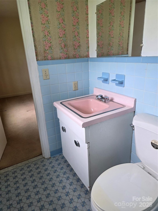 4298 NC-41 Hwy S, Fairmont, NC 28340 - bathroom featuring tile walls, vanity, toilet, wainscoting, and wallpapered walls