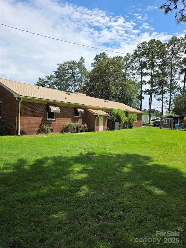 4298 NC-41 Hwy S, Fairmont, NC 28340 - rear view of property featuring brick siding, a lawn, and metal roof