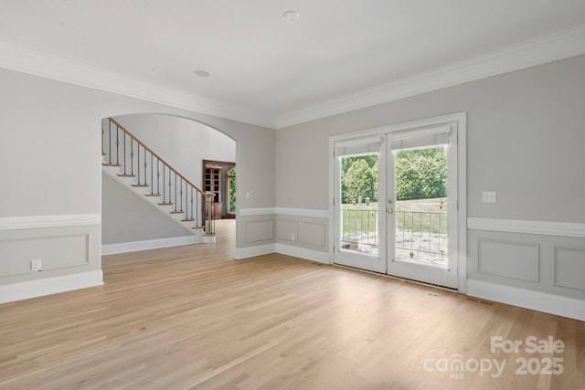 122 Long Cove Ln, Mooresville, NC 28117 - empty room featuring crown molding, arched walkways, a decorative wall, light wood-type flooring, and stairway