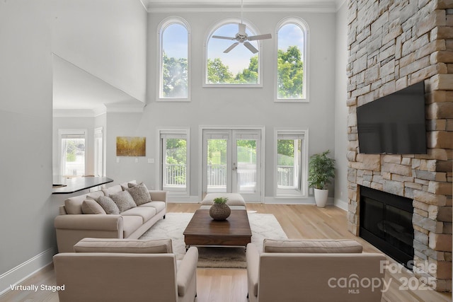 122 Long Cove Ln, Mooresville, NC 28117 - living area with a fireplace, a towering ceiling, crown molding, baseboards, and plenty of natural light