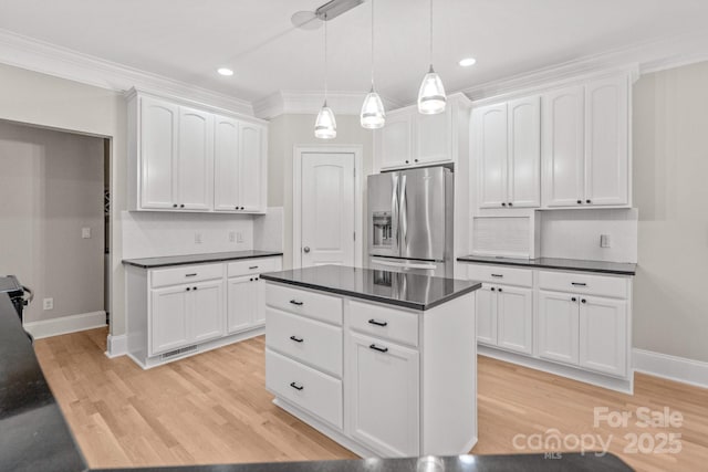 122 Long Cove Ln, Mooresville, NC 28117 - kitchen with stainless steel refrigerator with ice dispenser, dark countertops, white cabinetry, light wood-type flooring, and crown molding