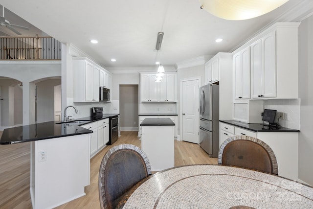122 Long Cove Ln, Mooresville, NC 28117 - kitchen featuring stainless steel appliances, a sink, light wood-style flooring, a peninsula, and dark countertops