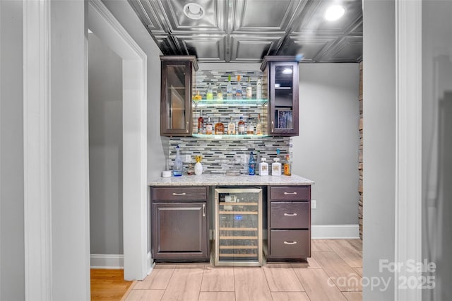 122 Long Cove Ln, Mooresville, NC 28117 - indoor dry bar featuring wine cooler, baseboards, an ornate ceiling, decorative backsplash, and light wood finished floors