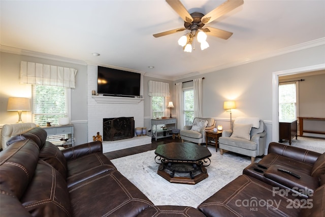 6511 Buggy Whip Ln, Waxhaw, NC 28173 - living room with ornamental molding, a brick fireplace, a ceiling fan, and wood finished floors