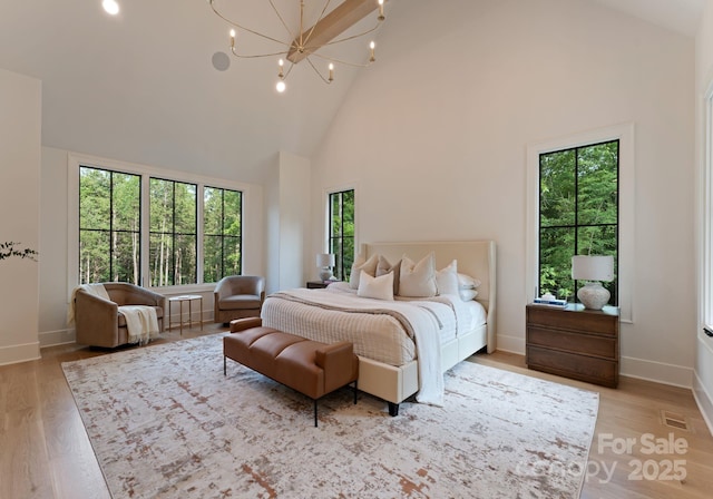 15037 June Washam Rd, Davidson, NC 28036 - bedroom with high vaulted ceiling, multiple windows, light wood-style flooring, a chandelier, and recessed lighting