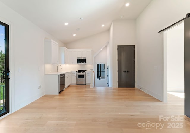 15037 June Washam Rd, Davidson, NC 28036 - kitchen featuring stainless steel appliances, a barn door, healthy amount of natural light, white cabinets, and recessed lighting