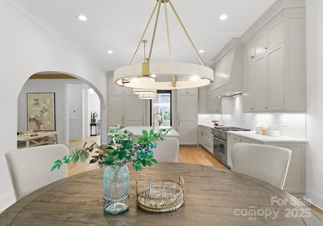 2921 Windsor Ave, Charlotte, NC 28209 - dining space with arched walkways, light wood-type flooring, recessed lighting, and a chandelier