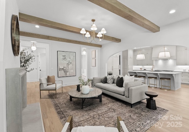 2921 Windsor Ave, Charlotte, NC 28209 - living area featuring beamed ceiling, arched walkways, a chandelier, light wood-type flooring, and recessed lighting