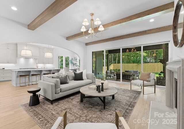 2921 Windsor Ave, Charlotte, NC 28209 - living area featuring a chandelier, beamed ceiling, arched walkways, light wood-style floors, and recessed lighting