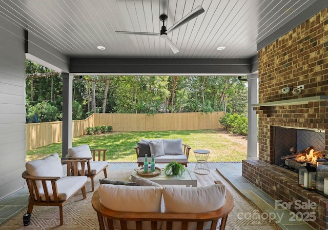 2921 Windsor Ave, Charlotte, NC 28209 - fenced backyard featuring an outdoor living space with a fireplace, a ceiling fan, and a patio area