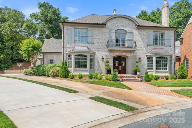 2954 Reynolds Sq, Winston Salem, NC 27106 - view of front of house featuring a balcony, french doors, brick siding, and a chimney