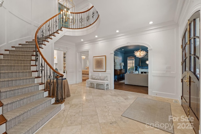 2954 Reynolds Sq, Winston Salem, NC 27106 - foyer entrance featuring a decorative wall, a chandelier, ornamental molding, stairway, and arched walkways