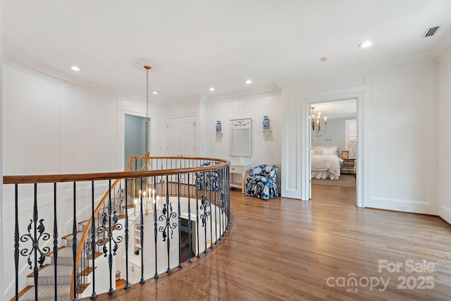 2954 Reynolds Sq, Winston Salem, NC 27106 - hallway featuring an upstairs landing, a chandelier, light wood-style flooring, crown molding, and recessed lighting