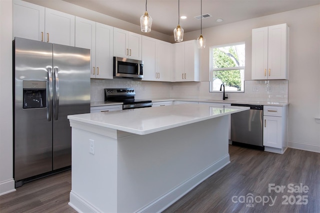 118 Durham Rd, Stanley, NC 28164 - kitchen featuring appliances with stainless steel finishes, dark wood-style flooring, a center island, white cabinets, and recessed lighting