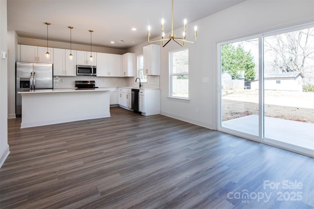 118 Durham Rd, Stanley, NC 28164 - kitchen featuring stainless steel appliances, a chandelier, dark wood-type flooring, white cabinetry, and baseboards