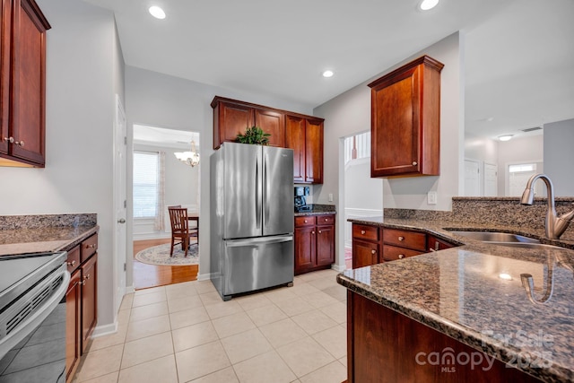 3351 Streamside Dr, Davidson, NC 28036 - kitchen with appliances with stainless steel finishes, dark stone counters, a chandelier, recessed lighting, and light tile patterned flooring