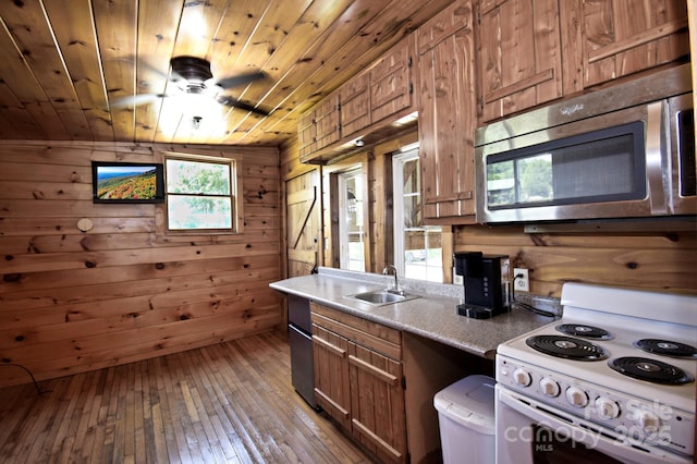 2967 Roby Martin Rd, Lenoir, NC 28645 - kitchen featuring stainless steel microwave, electric stove, a sink, brown cabinets, and wood walls