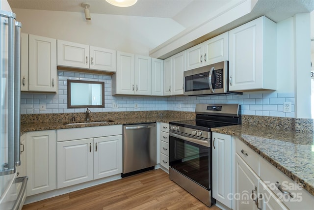 16 Red Barn Ln, Fletcher, NC 28732 - kitchen with stainless steel appliances, white cabinetry, backsplash, lofted ceiling, and dark stone countertops