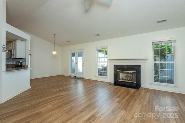 16 Red Barn Ln, Fletcher, NC 28732 - unfurnished living room featuring wood finished floors, a glass covered fireplace, ceiling fan, and lofted ceiling