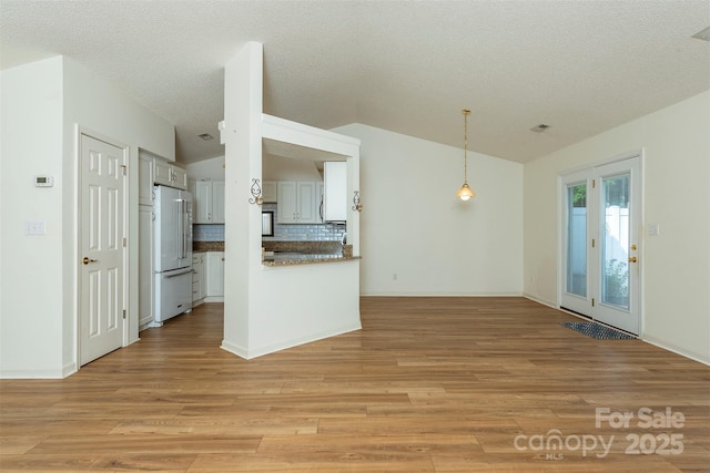 16 Red Barn Ln, Fletcher, NC 28732 - kitchen featuring high quality fridge, tasteful backsplash, light wood-style flooring, lofted ceiling, and open floor plan