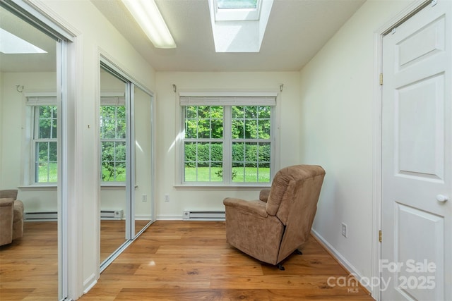 16 Red Barn Ln, Fletcher, NC 28732 - sitting room featuring a skylight, light wood-style flooring, a baseboard radiator, and baseboard heating