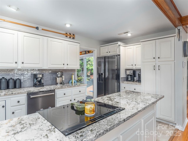 95 Harmon Ave, Lake Junaluska, NC 28745 - kitchen featuring appliances with stainless steel finishes, white cabinetry, backsplash, and light stone countertops