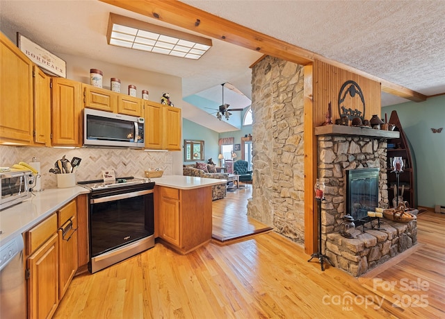 724 Pless Underwood Rd, Maggie Valley, NC 28751 - kitchen featuring stainless steel appliances, a peninsula, open floor plan, decorative backsplash, and light wood-type flooring