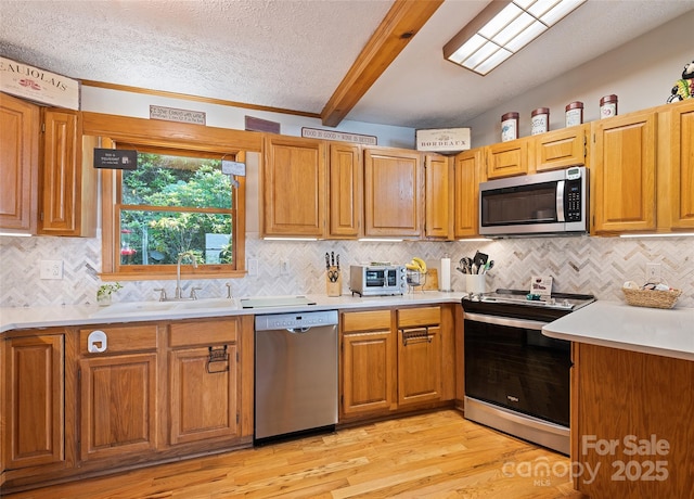 724 Pless Underwood Rd, Maggie Valley, NC 28751 - kitchen featuring appliances with stainless steel finishes, beam ceiling, light countertops, light wood-type flooring, and tasteful backsplash