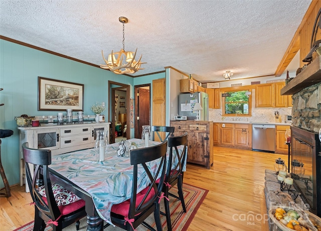 724 Pless Underwood Rd, Maggie Valley, NC 28751 - dining area featuring a chandelier, light wood-style floors, ornamental molding, and a textured ceiling